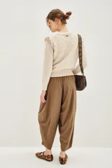 Pantalón tipo babucha de corte holgado y tiro alto, con cintura elástica y diseño de pierna amplia que se estrecha hacia los tobillos.