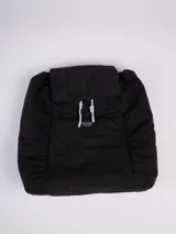 Mochila color camel con cierre superior con solapa y cordón ajustable. Tiene un bolsillo frontal con cierre y etiqueta con el logo de la marca. Las correas son negras y ajustables.