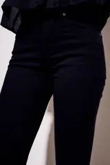 Jean negro de tiro medio con corte flare, confeccionado en algodón peinado.