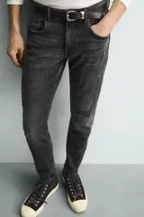 Jeans skinny fit de corte ajustado y tiro medio en color negro con efecto lavado y detalles desgastados. Confeccionados en tejido elástico con mezcla de algodón, presentan diseño clásico de cinco bolsillos y cierre frontal con cremallera y botón.
