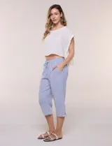 Pantalón capri de algodón a rayas verticales en tonos azul, celeste y blanco, con cintura elastizada, cordón de ajuste frontal y bolsillos aplicados.
