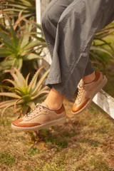 Zapatilla de cuero color beige con puntera y talón en cuero marrón.