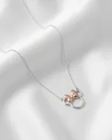 Collar de plata 925 con dije de Minnie Mouse, compuesto por un círculo plateado y un lazo con baño de oro rosa.