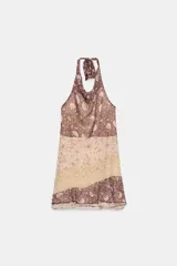 Vestido mini de cuello halter con espalda descubierta, detalle de tejido combinado con abalorios y bajo con volantes asimétricos.