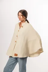 Capa cruda de lana merino uruguaya, con botones de madera y cuello adaptable.