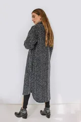 Tapado largo estilo chemise confeccionado en lana italiana tejida con patrón de espiga en color negro y gris. Presenta cierre frontal con botones y bolsillos con solapa.