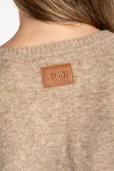 Sweater de tejido de punto con diseño de bloques de color en tonos beige, blanco roto y bordó. Presenta cuello redondo y mangas largas.