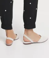 Zapatilla mule color marrón, con puntera fina y tira elástica en el tobillo.