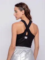 Top negro al cuerpo sin mangas con escote halter y cut-out en el pecho. Confeccionado en tela con destellos metálicos.