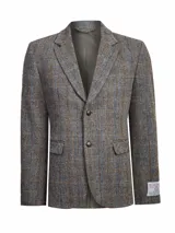 Blazer de lana Harris Tweed con patrón de espiga y cuadros sutiles en tonos tierra, azul y naranja. Presenta cierre frontal de dos botones, solapas clásicas y bolsillos con solapa. Incluye forro interior satinado.
