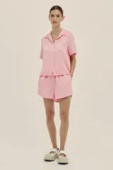 Short corto color rosa chicle, con bolsillos laterales, pretina con elástico y terminaciones en cobre insignia de la marca. El tejido lino-tencel es ideal para conseguir un look atemporal y natural.