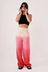 Pantalón sastrero de lino con diseño degradado en tonos beige y rosado, de tiro medio-alto, corte flared y pinzas en la cintura. Cuenta con bolsillos laterales y cierre con trabilla metálica.