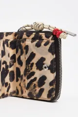 Billetera Bimba y Lola de color negro con detalles laterales en animal print y tirador de cierre de cuerda con cuentas rojas.