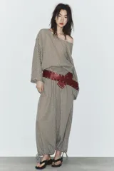 Pantalón de tiro medio con estampado de cuadros vichy en tonos beige y marrón. Cuenta con cintura elástica tipo nido de abeja y bajo ajustable con cordones.