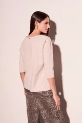 Remera oversize de algodón color blanco hueso, con cuello redondo y mangas 3/4.