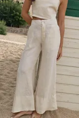 Pantalón palazzo color coral de lino con cintura alta y bolsillos laterales.