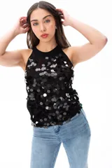 Musculosa negra con cuello halter y espalda descubierta, cubierta de lentejuelas plateadas.