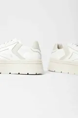 Zapatilla de gamuza color tostado con plataforma alta de goma blanca y cordones al tono.