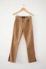 Pantalón de jean color café con corte recto, tiro alto, bolsillos delanteros y traseros, y tajos laterales en el ruedo. Presenta una franja vertical bordada en color rosa a lo largo de la costura lateral.