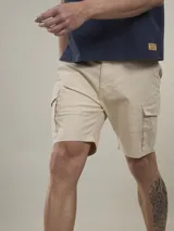 Bermuda cargo color marrón camel, confeccionada en twill con spandex, de calce cómodo y tiro medio. Cuenta con bolsillos laterales con solapa y bolsillos traseros con botón.