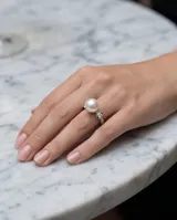 Anillo de plata 925 con una perla central y un detalle de circonia engastada en el lateral.