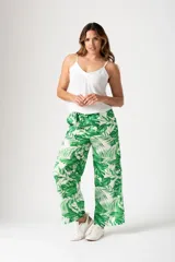 Pantalón palazo verde con estampado de hojas de palmera blancas, cintura elastizada con lazo y corte amplio.