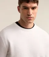 Suéter negro de tejido de punto maquinetado con cuello redondo y manga larga.