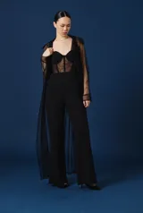 Trench de mujer largo y fluido, confeccionado en tela semitransparente de color negro, con cuello camisero y mangas largas.