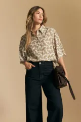 Jean de tiro alto y pierna ancha, confeccionado en denim azul oscuro con costuras a contratono. Presenta un diseño de corte recto y holgado.