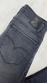 Pantalón jean negro skinny con roturas en las rodillas y muslos.