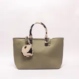 Cartera tipo tote de cuero sintético color verde militar, con asas de mano y detalles con estampado animal print de vaca. Incluye un monedero colgante a juego con el mismo estampado.