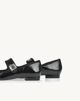 Ballerinas negras charoladas con punta fina, detalle de tira sobre el empeine con hebilla adornada con strass y pequeño taco cuadrado.