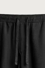 Pantalón de corte regular fit confeccionado en tejido mezcla de algodón, con cintura elástica ajustable mediante cordón, bolsillos laterales y bolsillos traseros de vivo.
