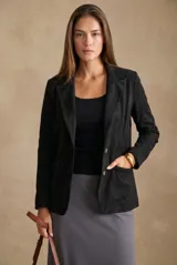Blazer negro de textura gamuzada con solapas clásicas, cierre frontal de dos botones y bolsillos laterales con solapa.