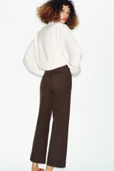 Jeans de tiro alto con diseño wide leg y corte cropped. Presenta cinco bolsillos, cierre frontal con cremallera y botón metálico.