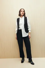 Pantalón de vestir color crema, de corte recto, con bolsillos laterales y cintura elastizada.