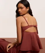 Blusa corta color terracota, con escote en V, breteles finos ajustables y detalle peplum en el dobladillo. Presenta aberturas en la espalda.