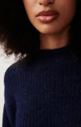 Sweater tejido verde esmeralda de alpaca y lana, con cuello redondo y mangas abullonadas.