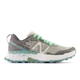 Championes de trail running New Balance Fresh Foam X Hierro v7 para mujer. Capellada de malla color gris con detalles en verde agua y verde claro. Suela Vibram Megagrip blanca con detalles en verde agua.