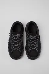 Championes negros con cordones gruesos en blanco y negro, suela gruesa con textura y puntera reforzada.