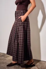 Pantalón de corte wide leg con diseño de cuadros, tiro medio y pinzas frontales que aportan volumen y movimiento a la prenda.