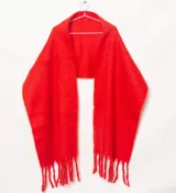 Mantón rojo con textura suave, de diseño amplio y flecos en los extremos.