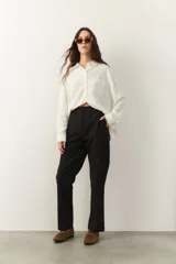 Pantalón negro de vestir, corte recto, con bolsillos laterales y falsos bolsillos traseros.