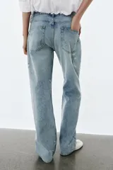 Jeans de tiro bajo y corte recto, con diseño de cinco bolsillos, trabillas en la cintura y efecto lavado con detalles de rotos en el frente.