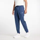 Pantalón deportivo New Balance de corte ajustado, color azul marino, con cintura elástica con cordón de ajuste y puños elásticos en los tobillos. Presenta el logo de la marca estampado en la pierna izquierda.