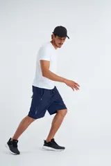 Short deportivo negro con cintura elástica ajustable con cordón, bolsillos laterales con cierre y detalles en verde flúor.