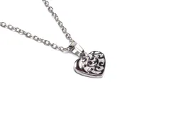 Collar con dije de acero antialérgico en forma de corazón con diseño calado.