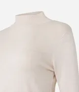 Suéter de punto color crema, con cuello alto, mangas largas y botones decorativos en los puños.