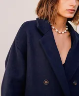 Abrigo oversize color ladrillo, confeccionado en lino pesado, con botonadura simple, bolsillos con solapa y ventilación trasera.