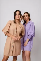 Vestido corto color tostado, con cuello solapa, abotonado al frente y mangas 3/4 con puños fruncidos.